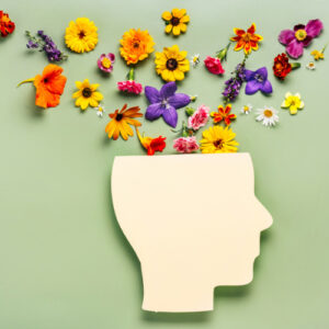 Flowers come out of paper cut out of human head. Trauma Healing.