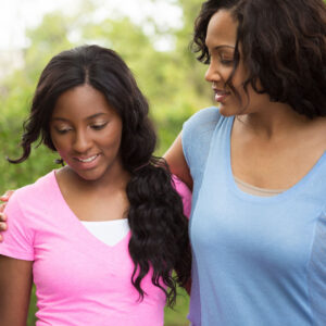 Mother has her arm around teenage daughter