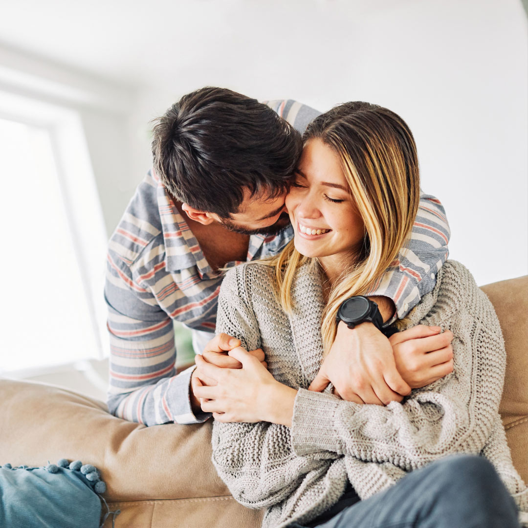 Man hugs woman smiling 