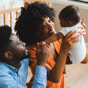 mother and father holding up baby